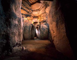 Newgrange passageway with triple spiral engraved on left.