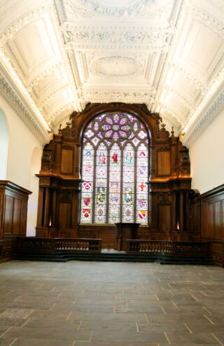 A bright stained glass window set within a mahogany inlay