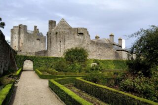 A castle looms over the walled garden in the foreground