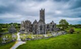 Quin Abbey and cemetery under a slate grey sky